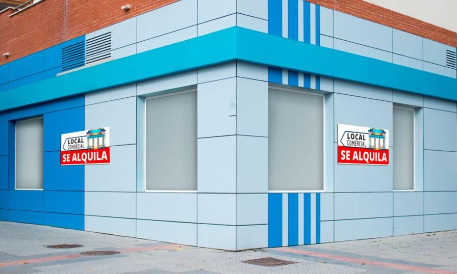 Contrato de Arrendamiento de local de negocio 1 Local comercial de esquina en color azul con carteles de alquiler, ideal para ilustrar el servicio de arrendamiento de local de negocio de VAHUMAR – Asesoría PYB.